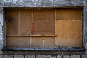 the windows of an abandoned building are boarded up