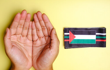 A picture praying hand with Palestinian Flag at side. Pray for Palestine concept