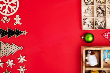 Simple wooden Christmas tree toys on a red background. background. copy space. Flat layout.