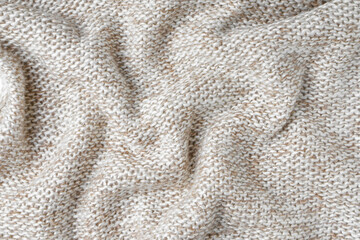 Beige and white color melange knitting cashmere wool cloth texture. Background of crumpled, wrinkled knit fabric, textile structure, cloth surface, weaving of knitwear material.