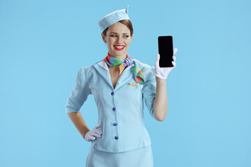 happy stewardess woman on blue showing smartphone blank screen