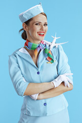happy stylish female air hostess on blue