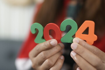Happy New Year 2024 concept, woman holding 2024 numbers