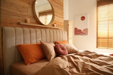 Bed with brown linens in cozy bedroom. Interior design
