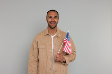 4th of July - Independence Day of USA. Happy man with American flag on light grey background, space...