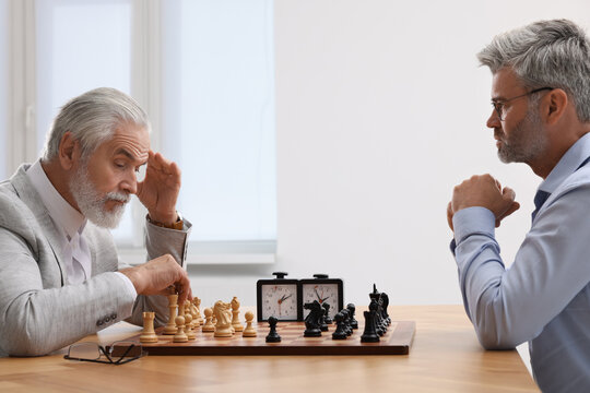 Men playing chess during tournament at table indoors
