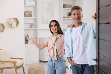 Obraz premium Happy couple welcoming near door. Invitation to come indoors