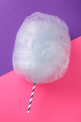 Sweet light blue cotton candy on color background, top view