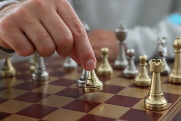 Man moving chess piece on checkerboard, closeup