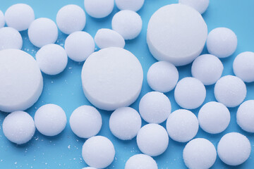 White mothballs on blue background.
