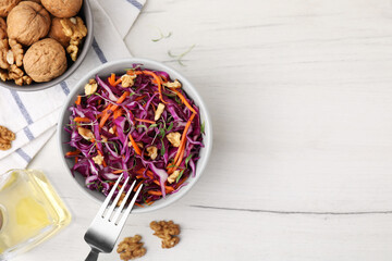Tasty salad with red cabbage and walnuts on white wooden table, flat lay. Space for text