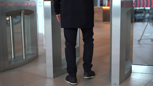 Businessman entering office building trough security gates. Media. Man passing through the turnstile.