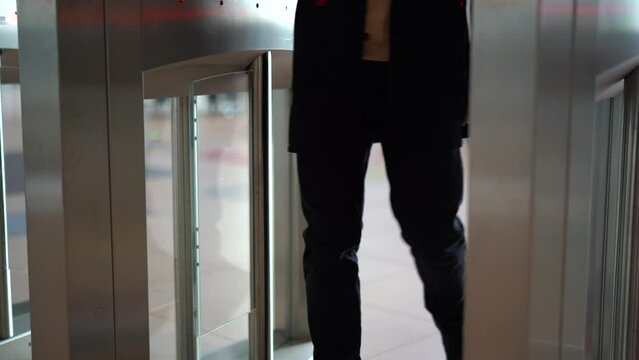 Businessman entering office building trough security gates. Media. Man passing through the turnstile.