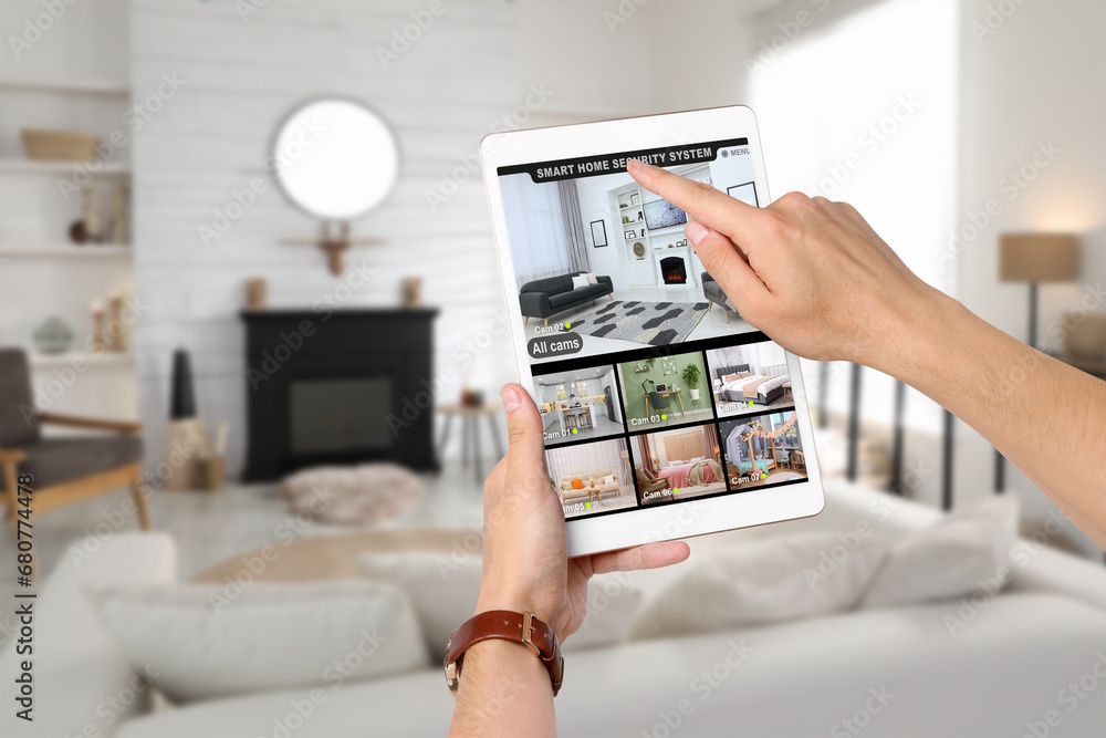 Aufkleber man using smart home security system on tablet computer indoors, closeup. device showing different r