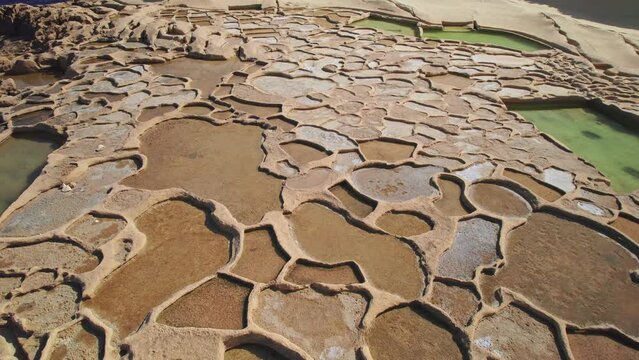 Reverse Dolly, Low Aerial of Salt Pans on Coast of Gozo Island, Malta