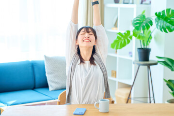 カジュアルな空間で深呼吸する若い女性
