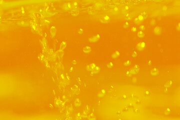 Defocus blurred transparent yellow colored clear calm water surface texture with splashes...