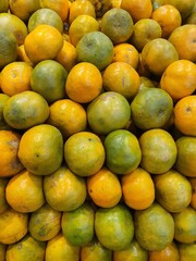 Close up pile of tasty fresh oranges sold at the market as a background.