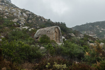 Strangely shaped large boulders on a side of a mountain at a remote location near Escondido, Southern California, on a rainy day