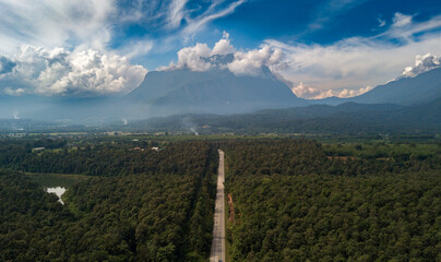 Aerial view of Doi Luang Chiang Dao mountain with a straight road among the forest on bright day at Chiang Dao, Chiang Mai, Thailand. aerial view of drone flying, The road leads beautifully to montain