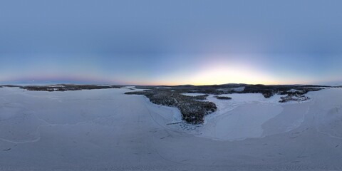 Dawn's soft light graces a vast snowy landscape near Kiruna's horizon.
