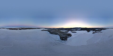 Dawn's soft light graces a vast snowy landscape near Kiruna's horizon.