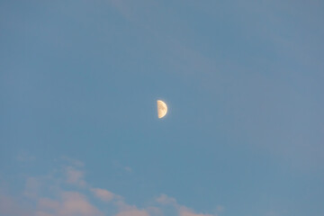The moon floating in the sunset sky.