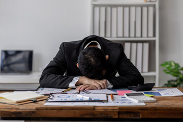 Tired exhausted business asian man sleepy and bored from sitting at a desk.tired of working in a...