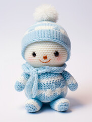 A small crochet snowman with a knitted hat and scarf