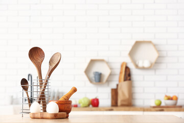 Cooking utensils and eggs on table in kitchen