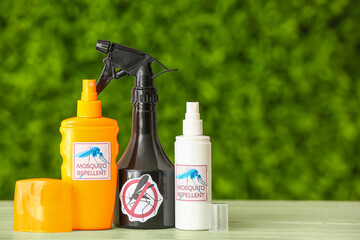 Bottles of mosquito repellent on table outdoors