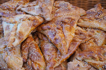 Puff pastry samosa with meat filling and sesame seeds.