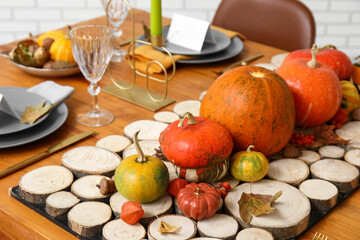 Festive table setting for Thanksgiving day with pumpkins and autumn leaves, closeup