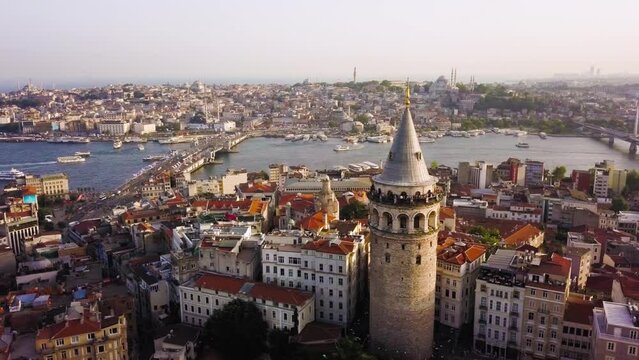Aerial circling Galata Tower, boat traffic on Golden Horn in background, Istanbul