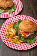 Homemade hamburger with fries on a wooden table.