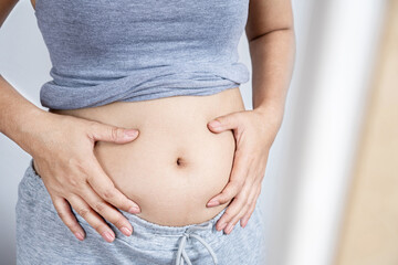pregnancy constipation, indigestion problem concept with pregnant woman holding stomach closeup