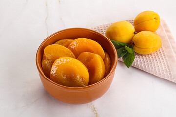 Few canned aprocots in the bowl