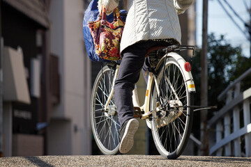 冬の街に自転車を乗っているシニア女性の姿