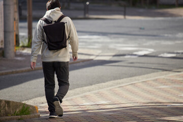 冬の朝の繁華街で歩く一人の男性サラリーマンの後姿