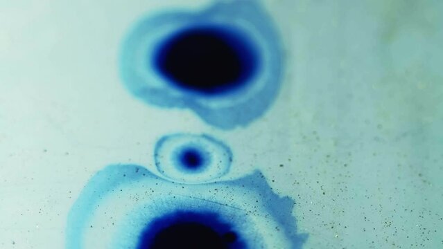 Ink drop. Paint splatter. Dye blotch. Blue black color gradient fluid wet stain spreading motion grain texture abstract free space background.