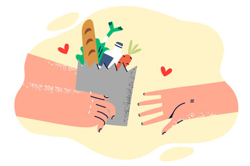 Paper bag with food in hands volunteer helping someone in need or delivering order from supermarket