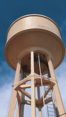 Isolated concrete water storage tower soars into blue sky