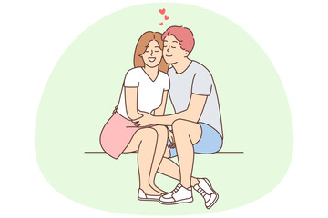 Happy couple sit outside hugging