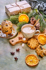 Christmas tree branches, gift box, coffee and oatmeal cookies on the table. New Year's composition
