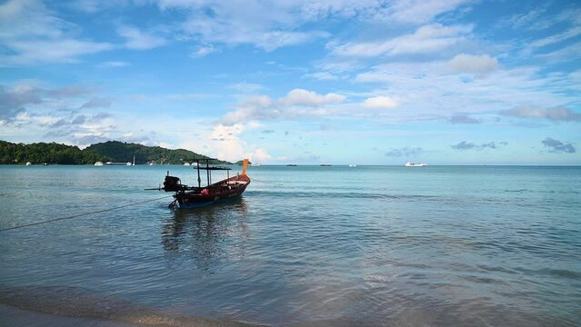 Long-tail fishing boats moored at Patong Beach on a clear day. beautiful beach It is the most beautiful beach and the most popular with tourists. in Phuket Province, Thailand.