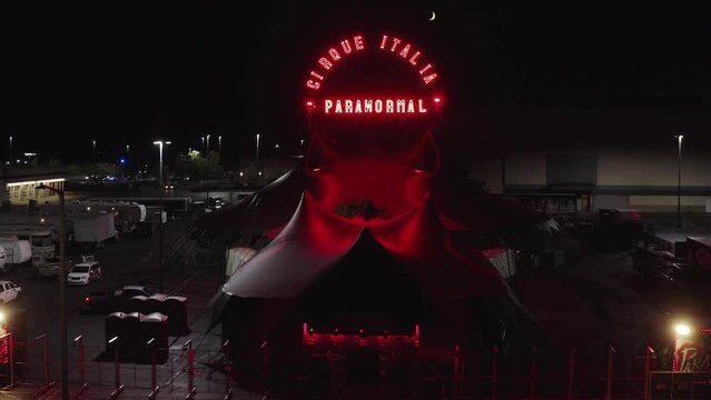 Venue Of Paranormal Cirque At Night. Horror-themed Traveling Circus In Washington, USA. aerial ascending shot