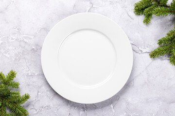 Mockup for a festive Christmas meal: Empty plate with festive fir tree branches