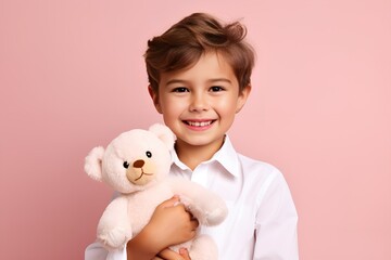 Adorable Fictional Young Kid in Plain Casual Shirt Holding a Teddy Bear and Smiling. Isolated on a plain pink background. Generative AI.