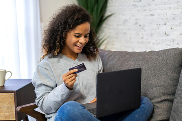 Portrait of african woman use technology laptop with credit card for fashion online shopping.Young...