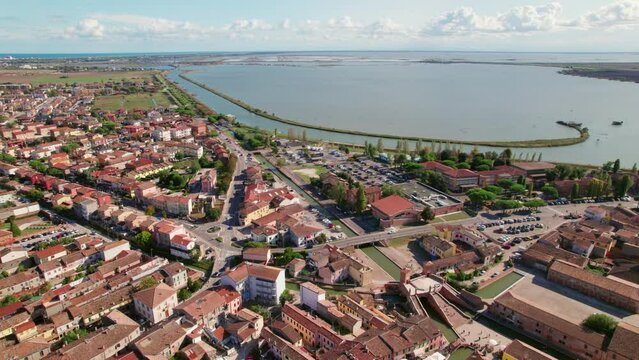 Comacchio, Italy, drone orbit view of urban infrastructure, city's canal and The Valli di Comacchio lagoon